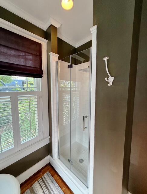 212 Jarnigan Ave, Chattanooga, TN 37405 - bathroom with baseboards, wood finished floors, a stall shower, and crown molding