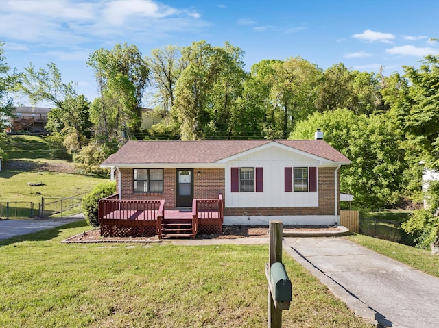 9027 Wooten Rd, Chattanooga, TN 37416 - view of front facade with fence, a front lawn, brick siding, and board and batten siding