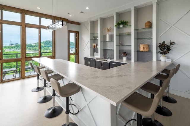 200 Manufacturers Rd Apt 428, Chattanooga, TN 37405 - kitchen featuring open shelves, a sink, a kitchen breakfast bar, decorative light fixtures, and recessed lighting