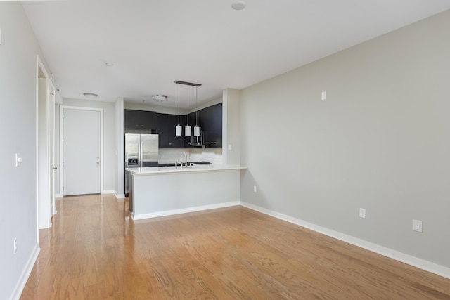 200 Manufacturers Rd Apt 428, Chattanooga, TN 37405 - kitchen with dark cabinetry, appliances with stainless steel finishes, light countertops, tasteful backsplash, and light wood-style floors