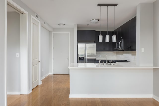 200 Manufacturers Rd Apt 428, Chattanooga, TN 37405 - kitchen featuring stainless steel appliances, a sink, dark cabinetry, light countertops, and tasteful backsplash