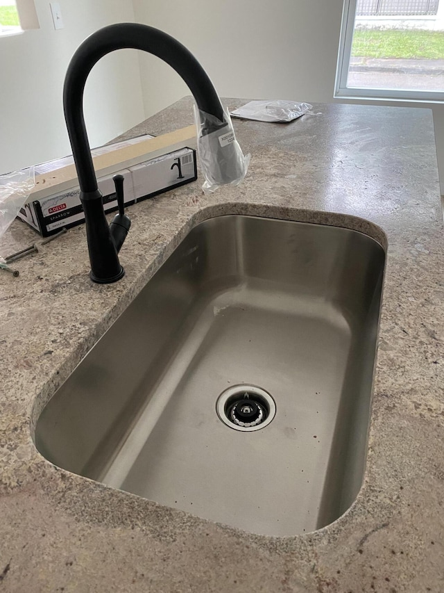interior details with a sink and stone counters