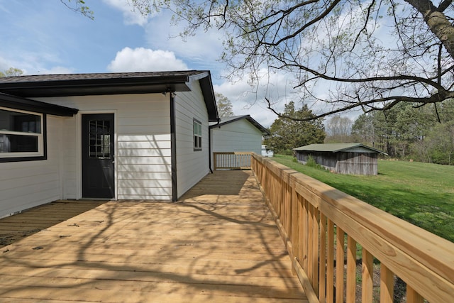 exterior space featuring an outdoor structure, a deck, and a lawn