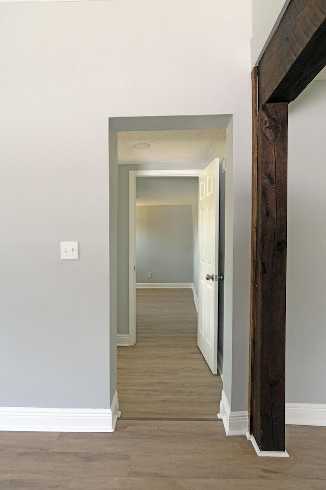 hall with wood finished floors and baseboards
