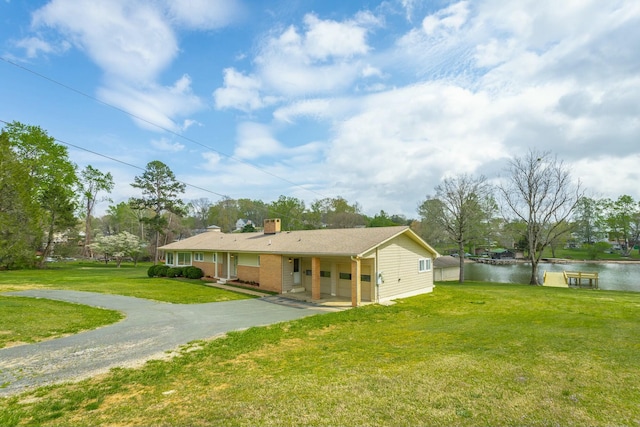 2041 Linwood Cir, Soddy Daisy, TN 37379 - ranch-style house with concrete driveway, a chimney, a garage, a front yard, and a water view