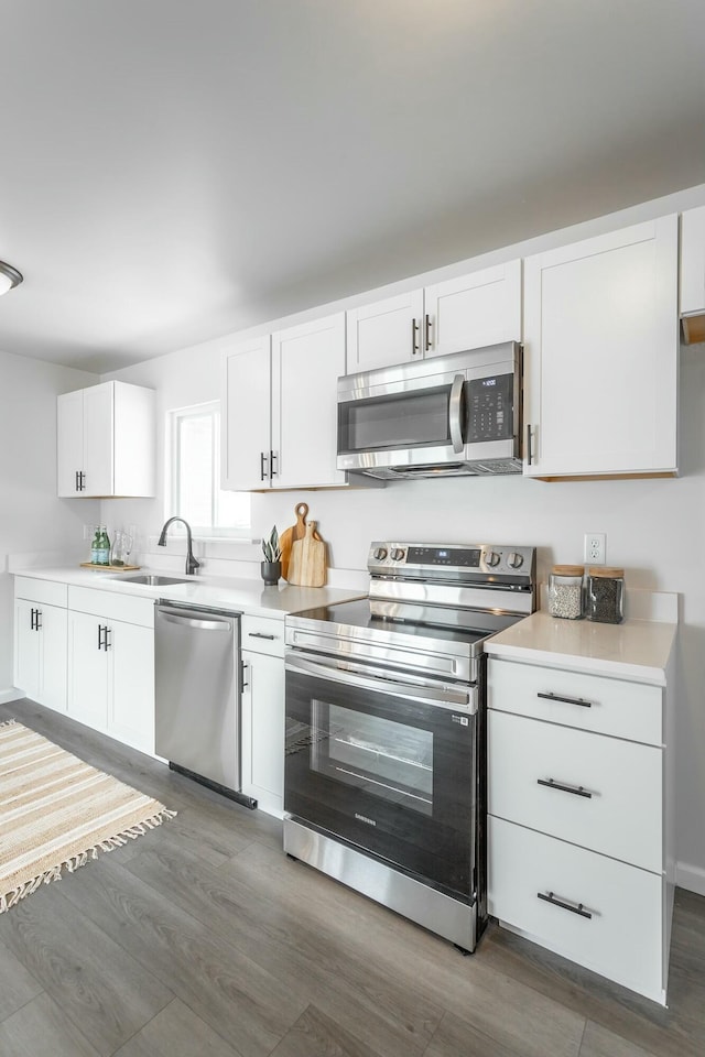 2041 Linwood Cir, Soddy Daisy, TN 37379 - kitchen featuring dark wood-type flooring, white cabinets, light countertops, a sink, and stainless steel appliances