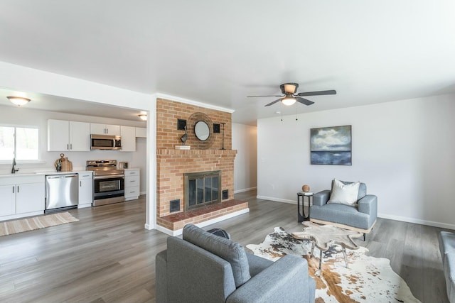 2041 Linwood Cir, Soddy Daisy, TN 37379 - living room featuring light wood-type flooring, ceiling fan, baseboards, and a fireplace