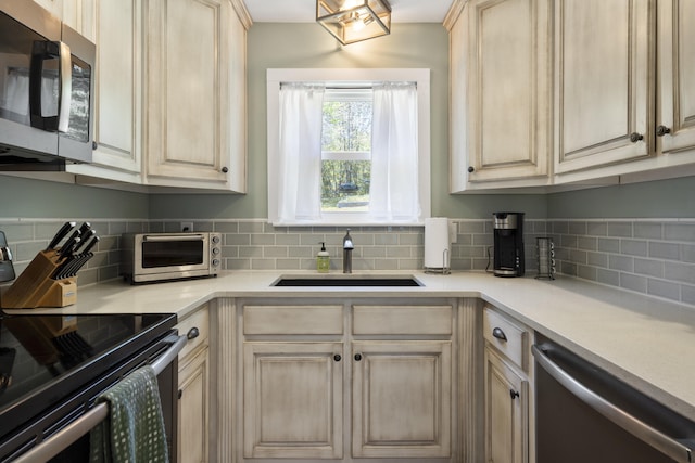 811 Snow St, Chattanooga, TN 37405 - kitchen with a toaster, a sink, tasteful backsplash, light countertops, and appliances with stainless steel finishes