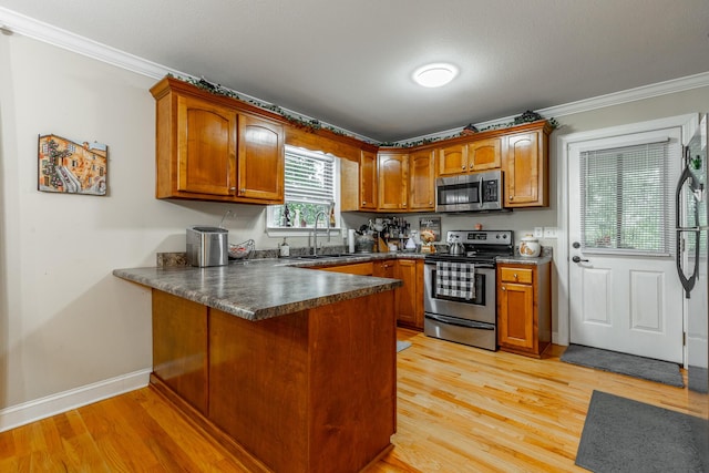 901 Haggard Rd, Ringgold, GA 30736 - kitchen featuring stainless steel appliances, a peninsula, brown cabinetry, crown molding, and dark countertops