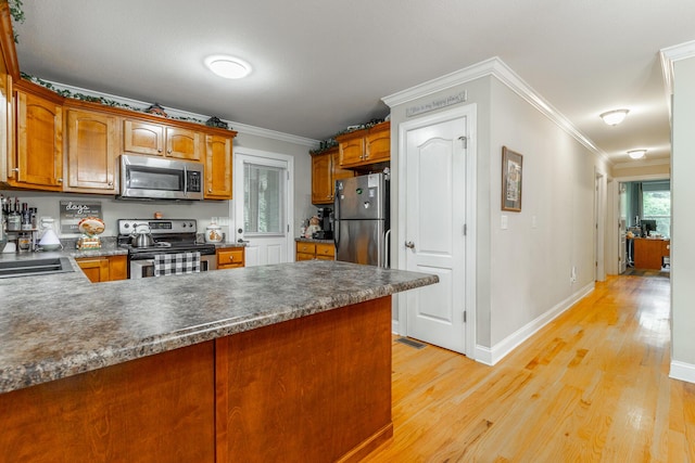 901 Haggard Rd, Ringgold, GA 30736 - kitchen featuring stainless steel appliances, a peninsula, light wood-style floors, crown molding, and brown cabinetry