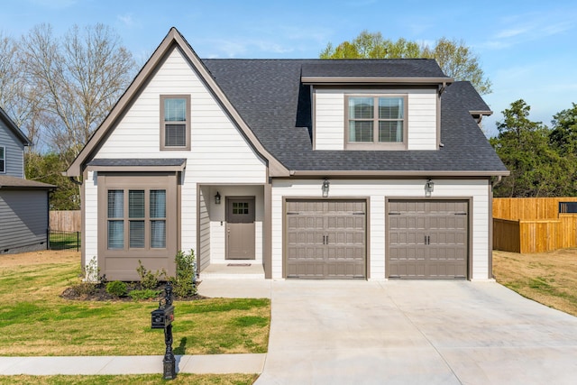 view of front of property with concrete driveway, a garage, fence, and a front yard