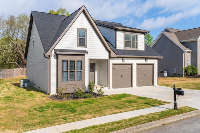 view of front of house with roof with shingles, driveway, cooling unit, a front lawn, and a garage