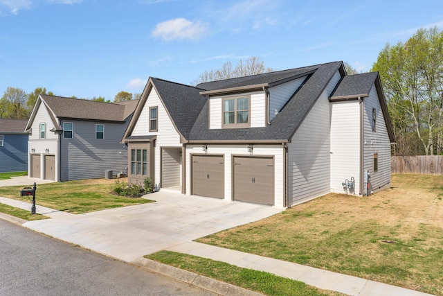 view of front of property with roof with shingles, a front yard, fence, an attached garage, and driveway
