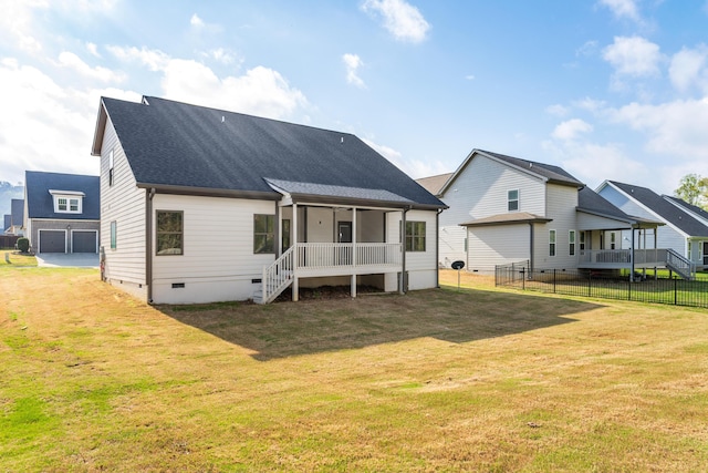 rear view of house featuring roof with shingles, crawl space, fence, and a lawn