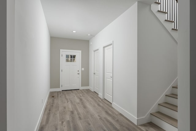 interior space with baseboards, stairway, recessed lighting, and light wood finished floors