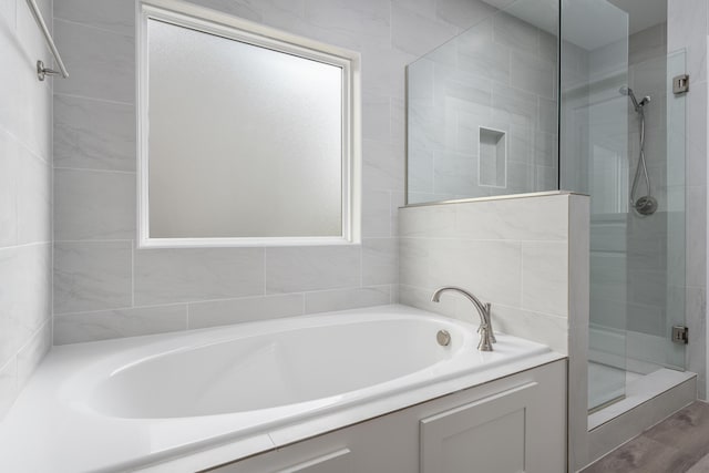 bathroom with a shower stall and a garden tub