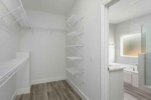 spacious closet featuring wood finished floors and visible vents