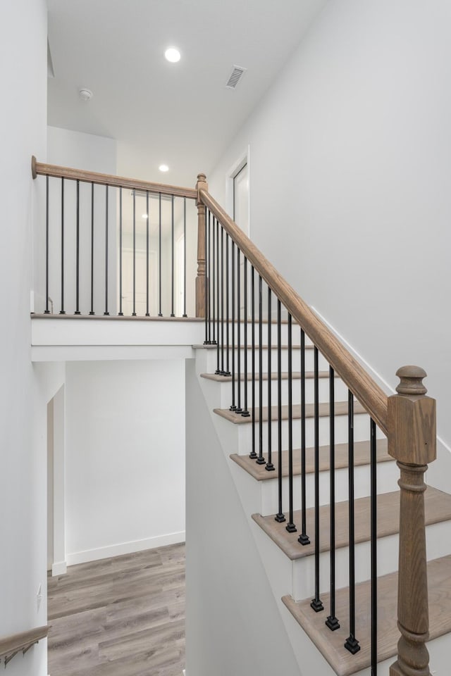 staircase featuring visible vents, baseboards, recessed lighting, and wood finished floors