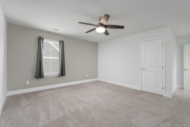 carpeted spare room with ceiling fan, baseboards, and visible vents