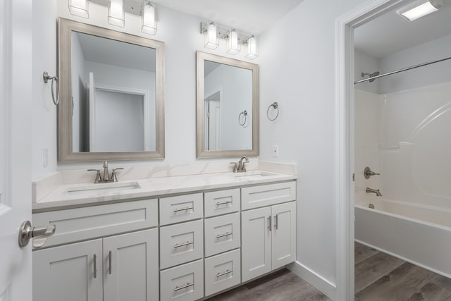 full bathroom featuring a sink, double vanity, shower / bath combination, and wood finished floors