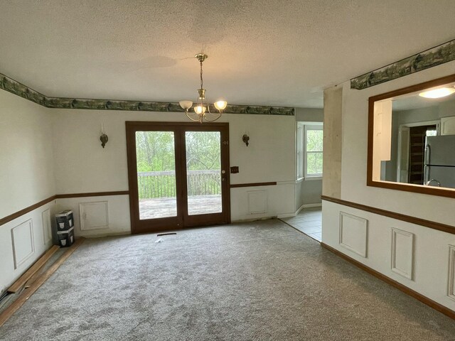 809 Chestnut Wood Ln, Chattanooga, TN 37421 - unfurnished dining area featuring light colored carpet, an inviting chandelier, and a textured ceiling