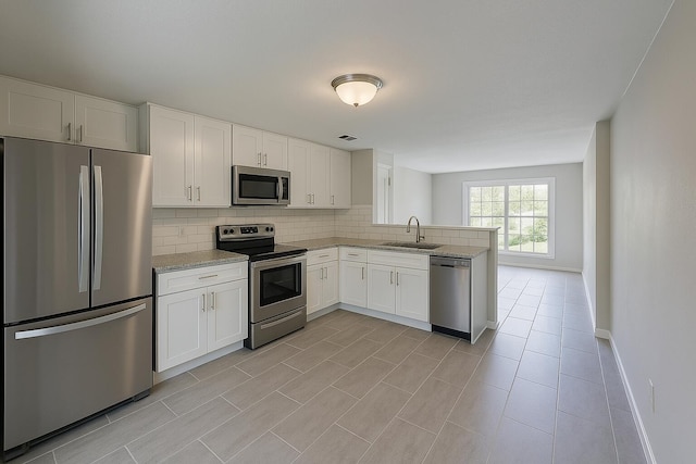 4831 Bonny Lake Ln, Chattanooga, TN 37416 - kitchen with tasteful backsplash, a peninsula, white cabinets, appliances with stainless steel finishes, and a sink