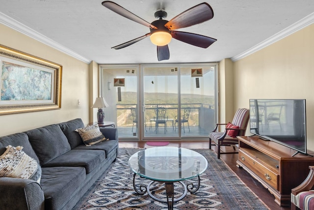 living area with ornamental molding, wood finished floors, a ceiling fan, and a wall of windows