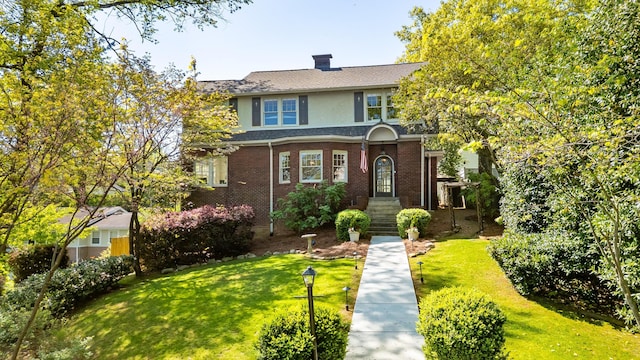traditional home featuring a front lawn, brick siding, roof with shingles, and a chimney