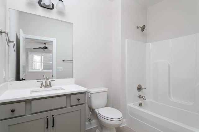 bathroom featuring ceiling fan, bathing tub / shower combination, vanity, toilet, and baseboards