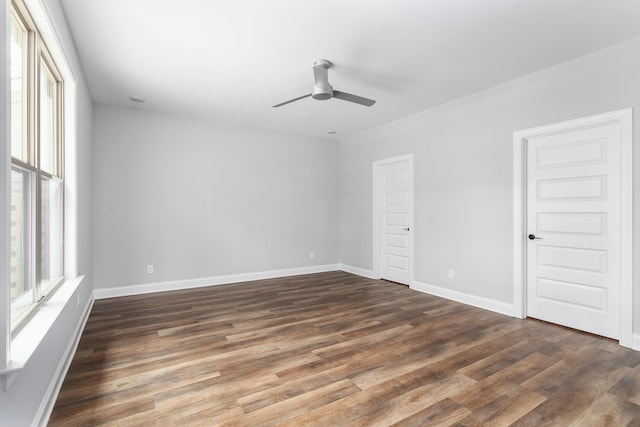 unfurnished bedroom featuring dark wood-style flooring, baseboards, and a ceiling fan