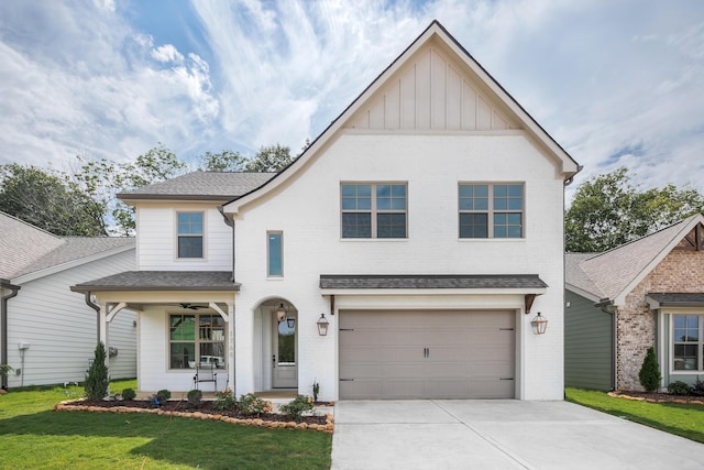 view of front of home featuring a garage, board and batten siding, brick siding, a front lawn, and driveway