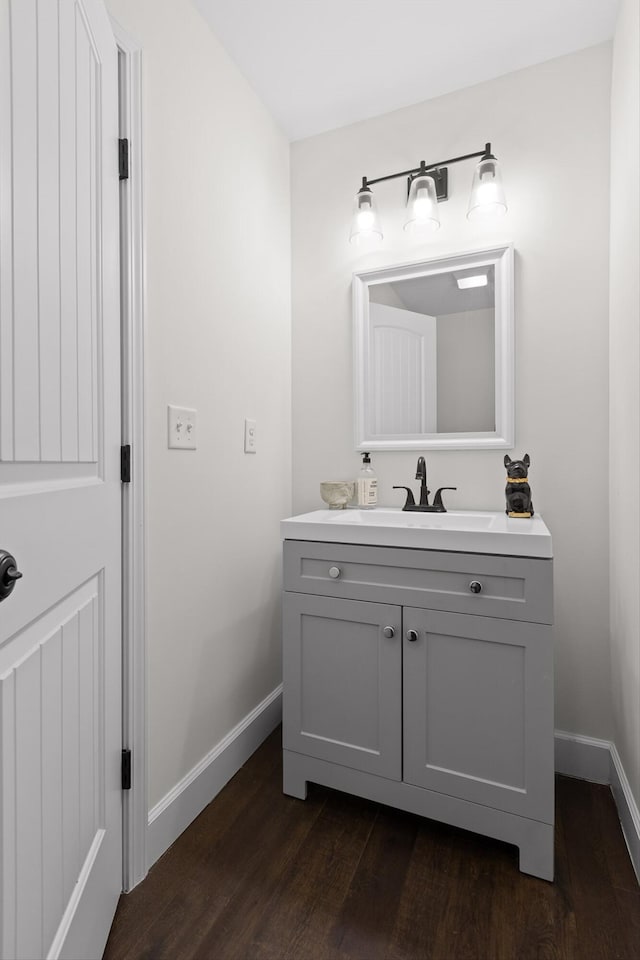 bathroom with wood finished floors, vanity, and baseboards