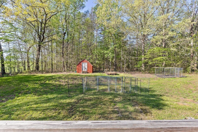 view of yard with a shed, fence, and an outbuilding