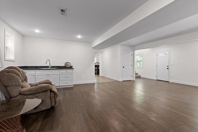 living room featuring visible vents, baseboards, recessed lighting, and dark wood-style floors