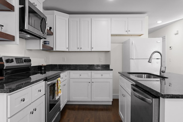kitchen featuring dark wood-type flooring, a sink, white cabinets, and stainless steel appliances