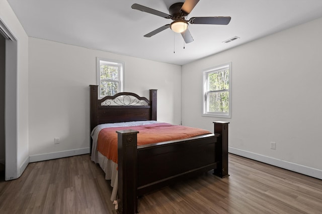 bedroom with visible vents, baseboards, and wood finished floors