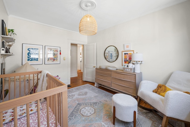 1209 Highland Dr, Chattanooga, TN 37405 - bedroom featuring wood finished floors, baseboards, ornamental molding, and a crib