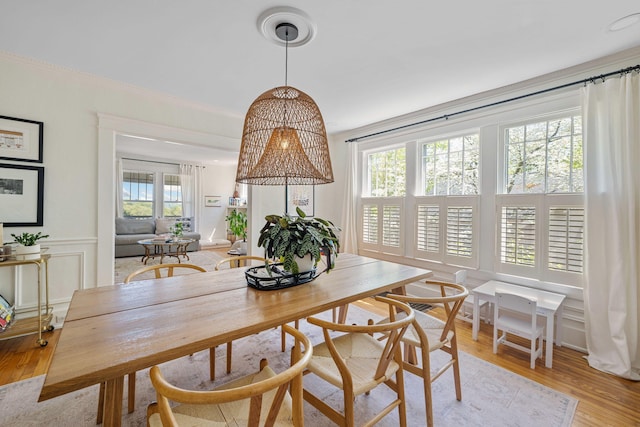 1209 Highland Dr, Chattanooga, TN 37405 - dining space featuring a decorative wall, a wainscoted wall, light wood-type flooring, and crown molding