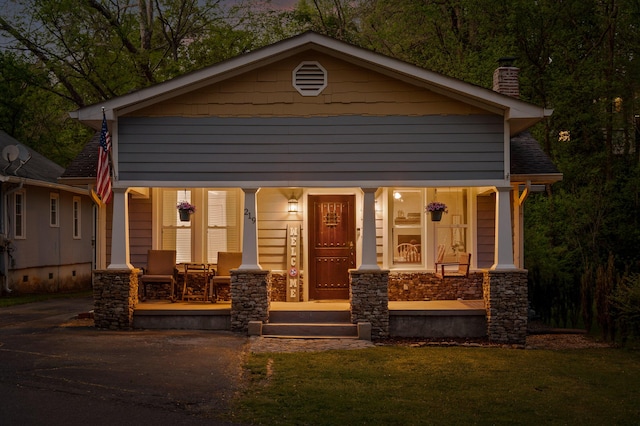 219 Martin Rd, Chattanooga, TN 37415 - view of front of home featuring covered porch, a chimney, stone siding, and a front lawn