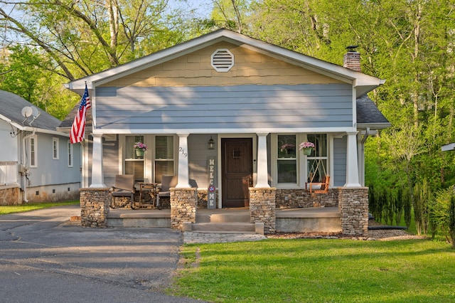 219 Martin Rd, Chattanooga, TN 37415 - view of front of property featuring covered porch, a chimney, stone siding, roof with shingles, and a front yard