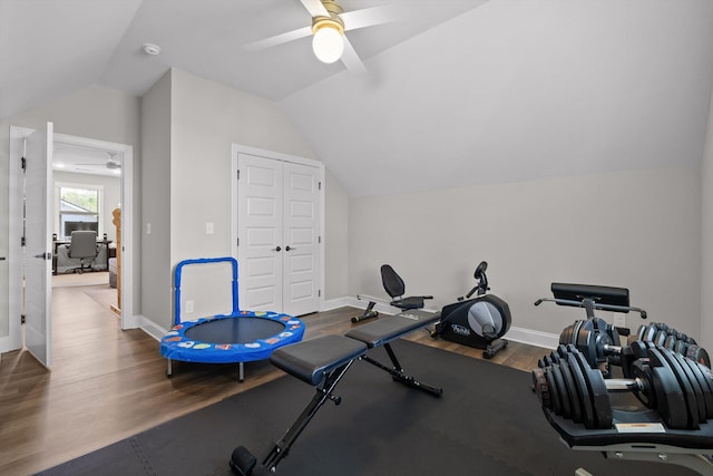 exercise room with vaulted ceiling, baseboards, a ceiling fan, and wood finished floors