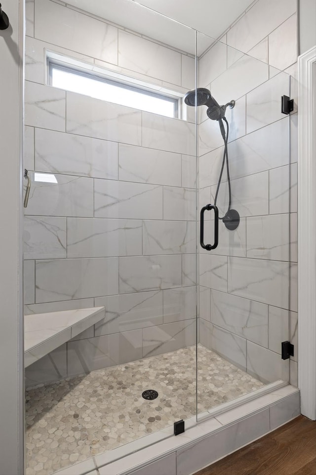 bathroom featuring a shower stall, plenty of natural light, and wood finished floors