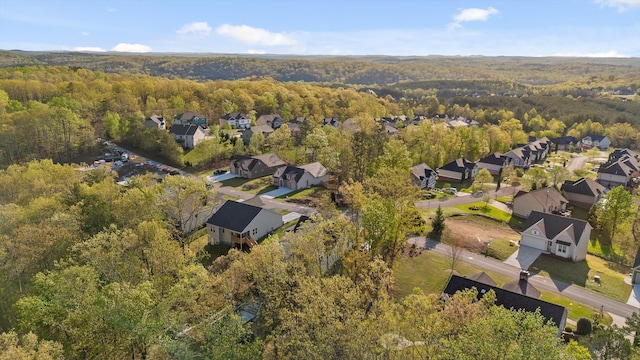 drone / aerial view with a wooded view and a residential view