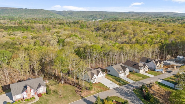 drone / aerial view featuring a residential view and a wooded view
