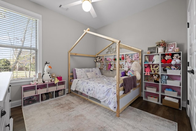 bedroom featuring baseboards, ceiling fan, visible vents, and wood finished floors