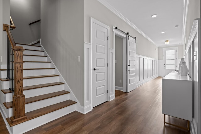 staircase with recessed lighting, a barn door, baseboards, ornamental molding, and wood finished floors