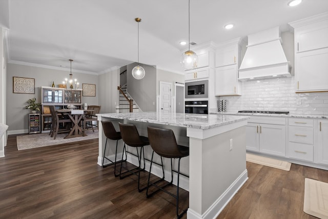 kitchen with wall oven, built in microwave, a center island, stainless steel gas cooktop, and custom range hood