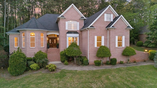 7111 River Run Dr, Chattanooga, TN 37416 - traditional home featuring a front yard, a shingled roof, and brick siding