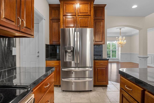 7111 River Run Dr, Chattanooga, TN 37416 - kitchen featuring arched walkways, brown cabinets, stainless steel fridge with ice dispenser, and a wainscoted wall