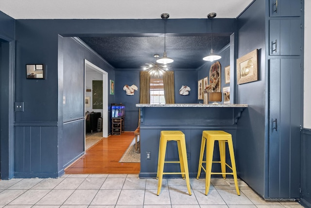 1905 Bella Vista Dr, Chattanooga, TN 37421 - kitchen featuring crown molding, light tile patterned floors, pendant lighting, and a kitchen bar